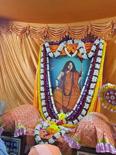 Festivals & Observances: A garlanded portrait of Acharya Swami Pranavananda set up for worship on a decorated dais