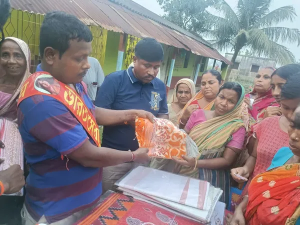 Relief Work: Volunteers distributing new saris and dhotis to women at a relief distribution