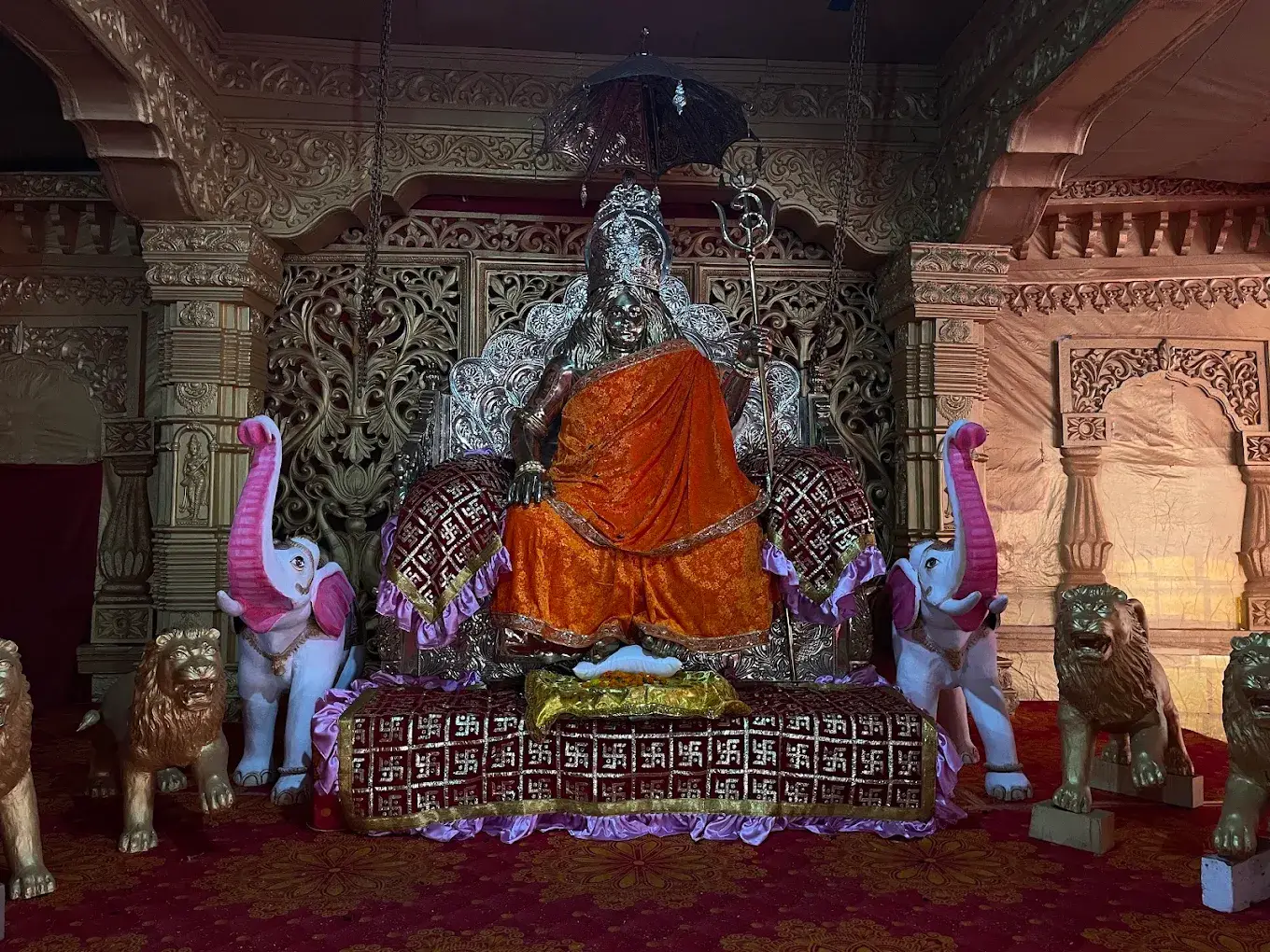 The temple shrine, with the seated figure of Acharya Swami Pranavananda flanked by carved lions and elephants